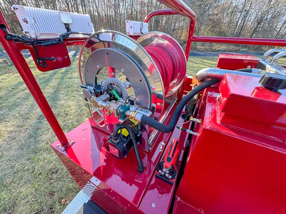 Rear deck area near hose reel with control hardware and piping.