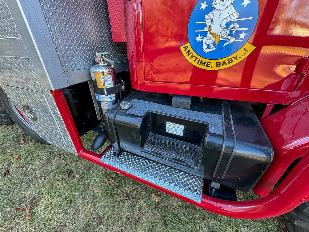Lower cab side close-up with side step and mounted extinguisher.