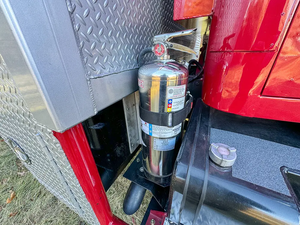 Vertical cylinder and filter assembly close-up at cab step area.