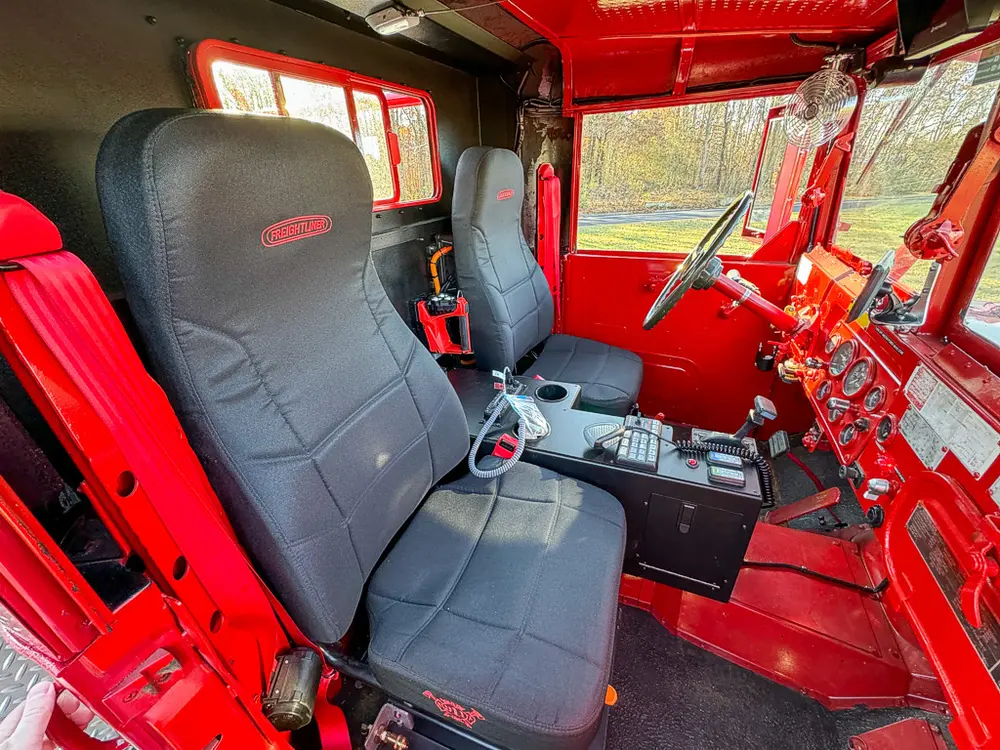 Driver-seat interior view with control levers and center console.