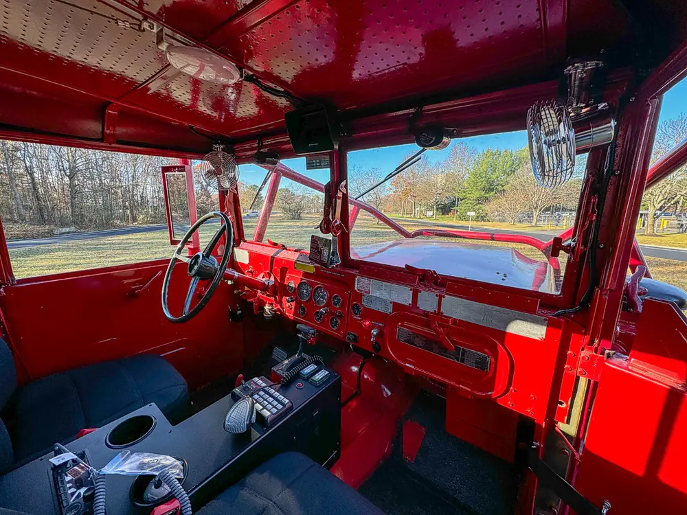 Cab interior from passenger side showing steering wheel and dashboard.