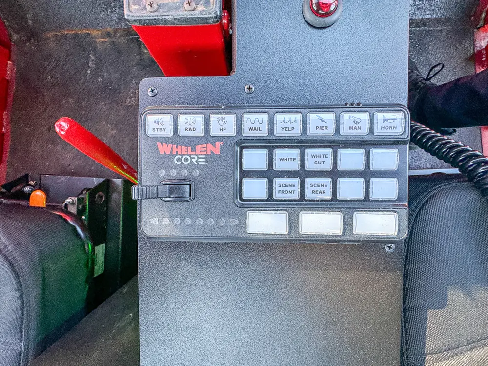 Close-up of Whelen control keypad mounted beside the seat.