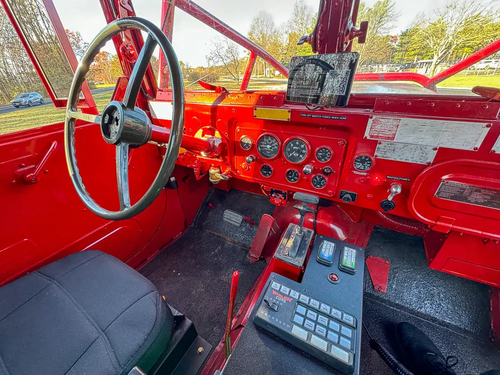 Cab front view with steering wheel, levers, and instrument panel.