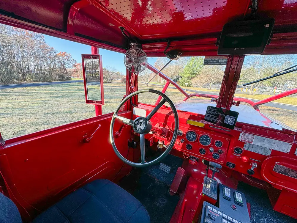 Driver-side interior view with steering wheel and gauge cluster.