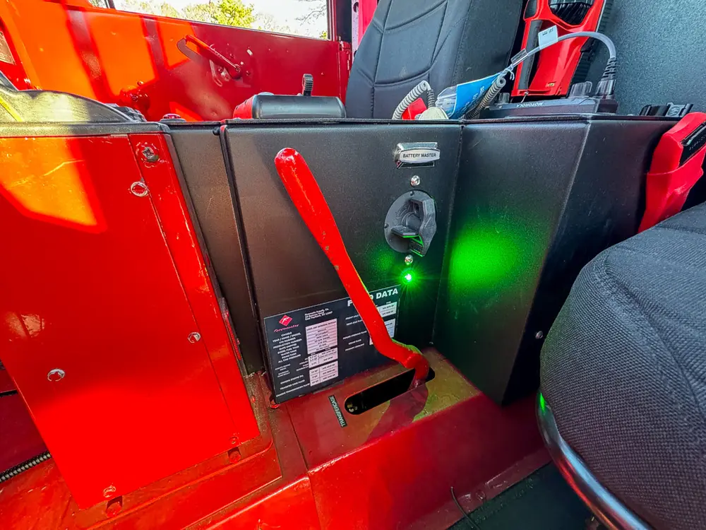 Driver-side control panel close-up with red lever and indicator light.