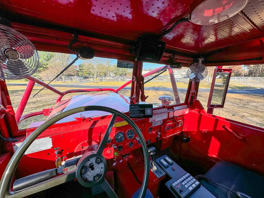 Cab upper interior view with dual steering wheels and overhead fans.