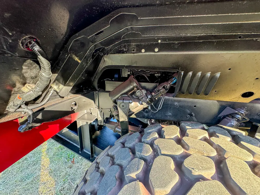 Front suspension and underbody close-up near the wheel.