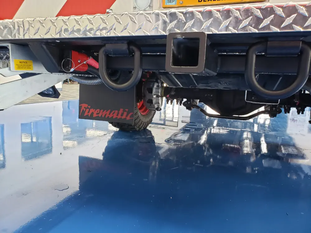 Exterior view of small fire truck showing cab, body compartments, and wheel/tire area.