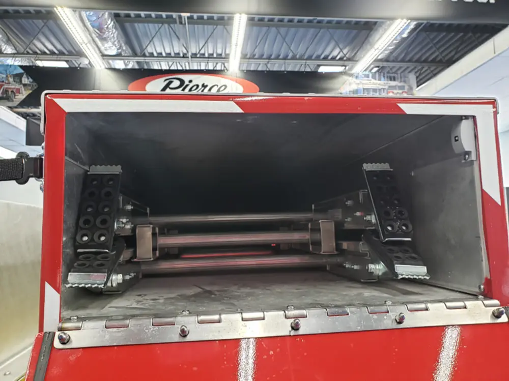 Exterior view of small fire truck showing cab, body compartments, and wheel/tire area.