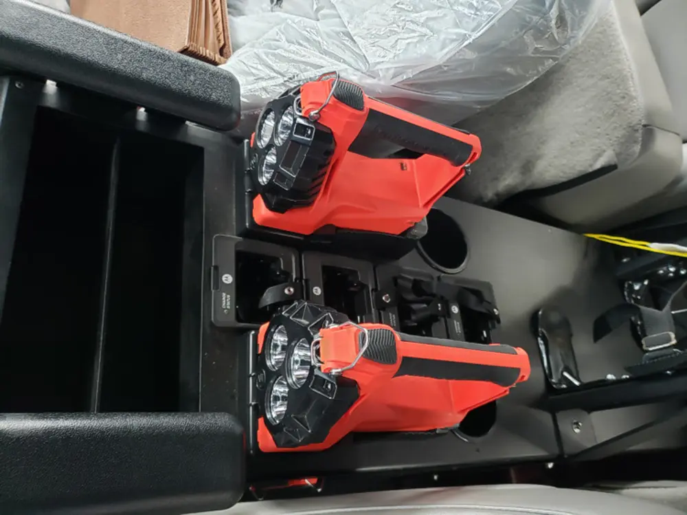 Exterior view of small fire truck showing cab, body compartments, and wheel/tire area.