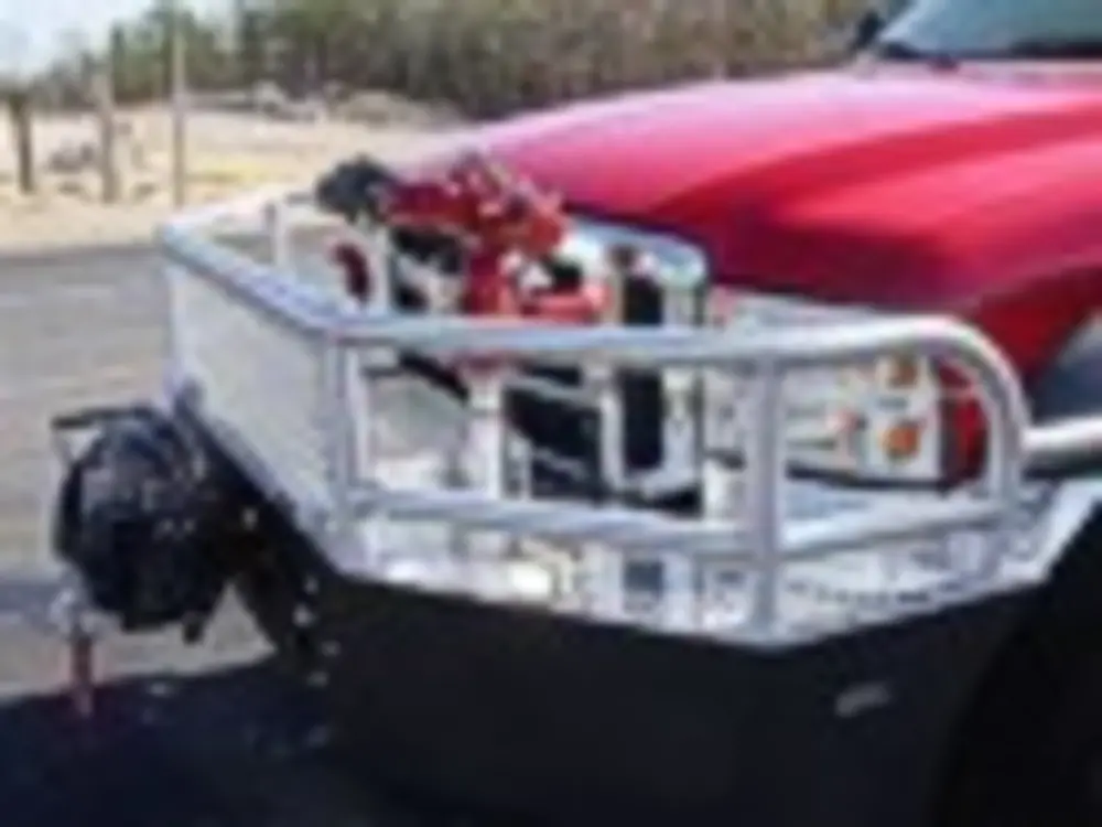 Exterior view of small fire truck showing cab, body compartments, and wheel/tire area.