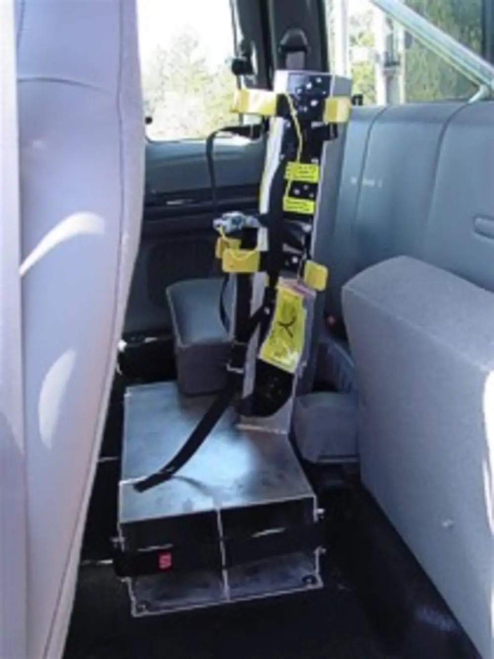 Exterior view of small fire truck showing cab, body compartments, and wheel/tire area.