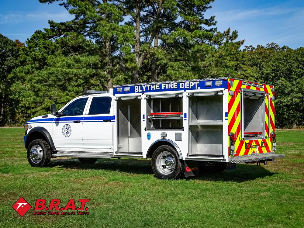 Exterior view of small fire truck showing cab, body compartments, and wheel/tire area.