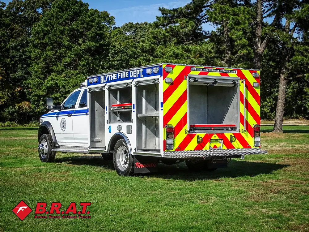 Exterior view of small fire truck showing cab, body compartments, and wheel/tire area.