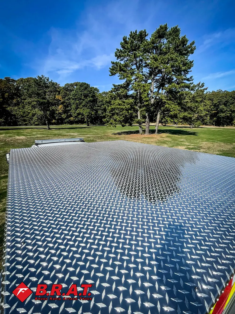 Exterior view of small fire truck showing cab, body compartments, and wheel/tire area.