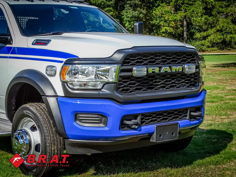 Exterior view of small fire truck showing cab, body compartments, and wheel/tire area.