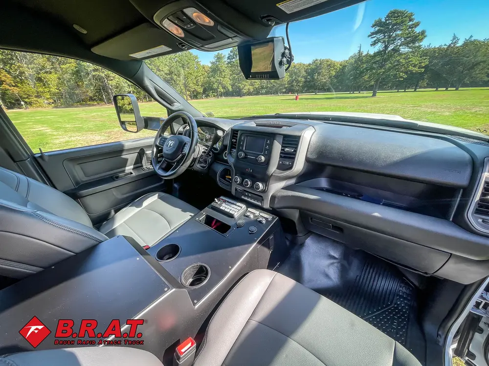 Exterior view of small fire truck showing cab, body compartments, and wheel/tire area.