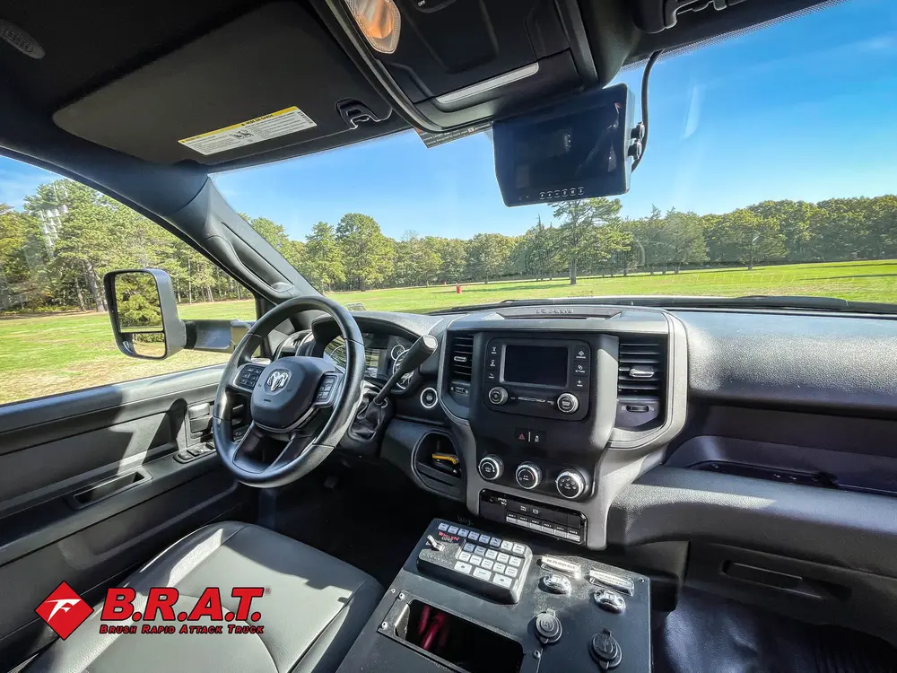 Exterior view of small fire truck showing cab, body compartments, and wheel/tire area.