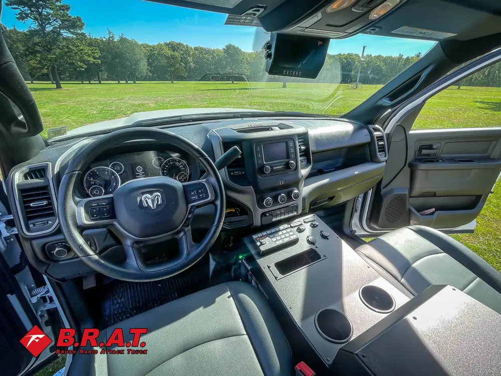 Exterior view of small fire truck showing cab, body compartments, and wheel/tire area.