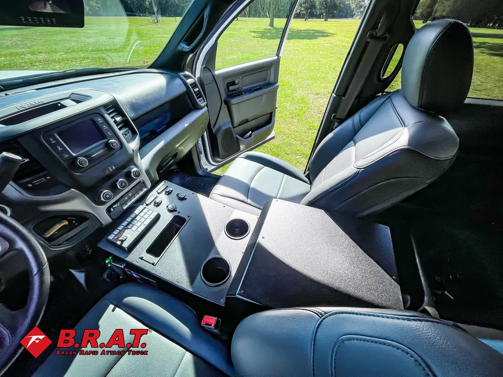 Exterior view of small fire truck showing cab, body compartments, and wheel/tire area.