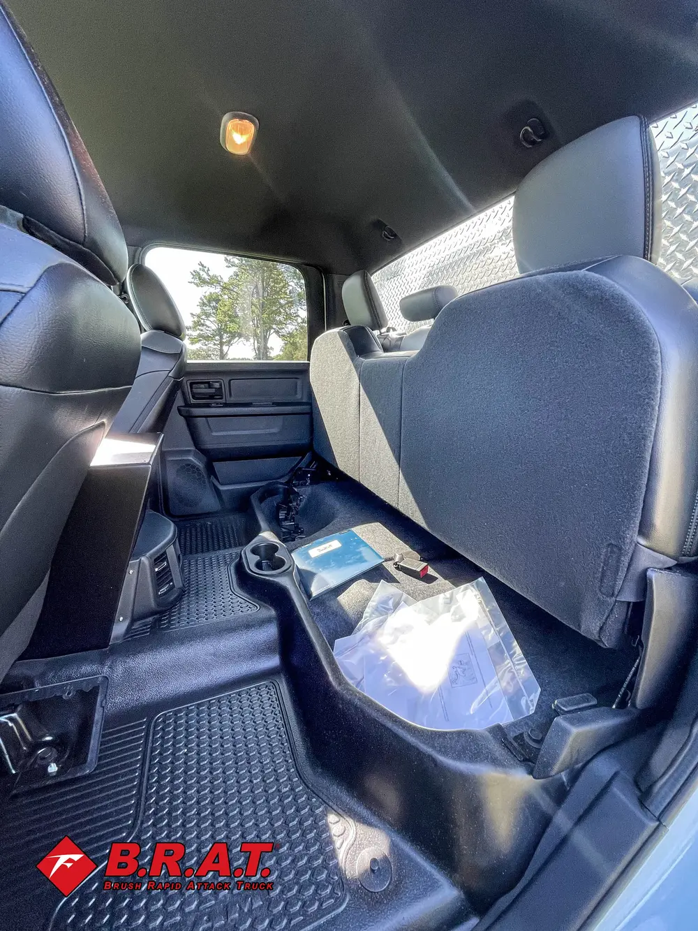 Exterior view of small fire truck showing cab, body compartments, and wheel/tire area.