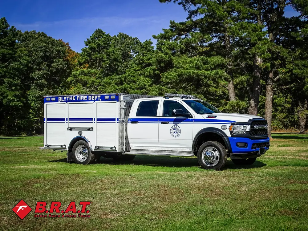 Exterior view of small fire truck showing cab, body compartments, and wheel/tire area.