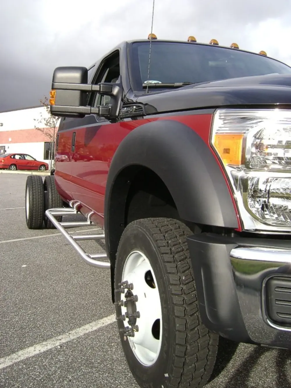 Exterior view of small fire truck showing cab, body compartments, and wheel/tire area.