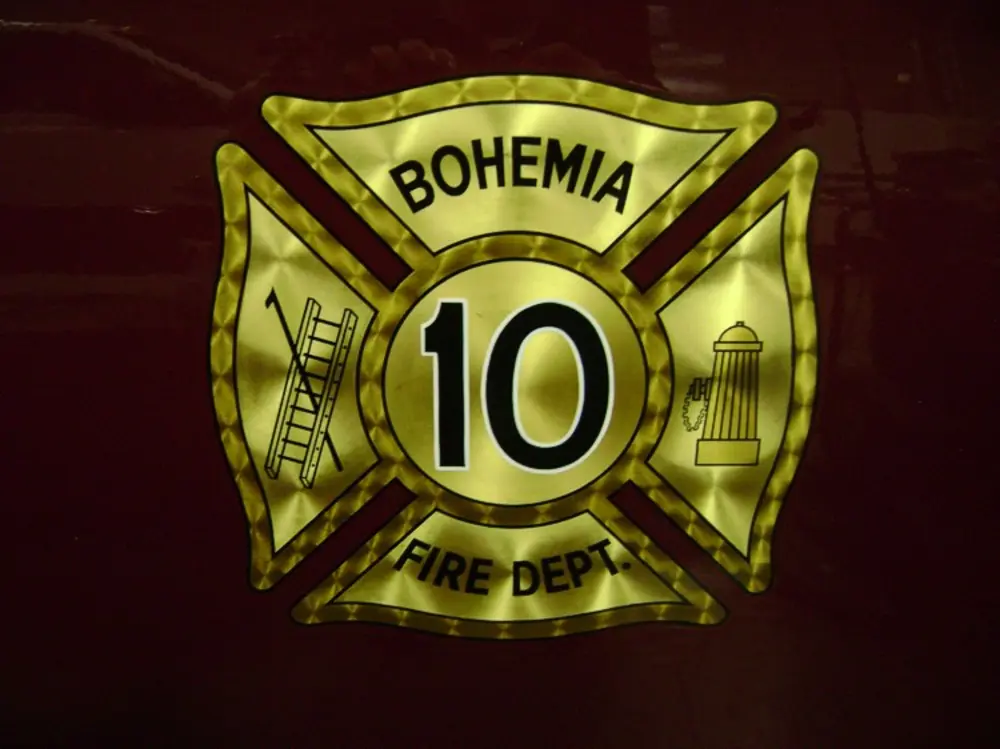 Exterior view of small fire truck showing cab, body compartments, and wheel/tire area.