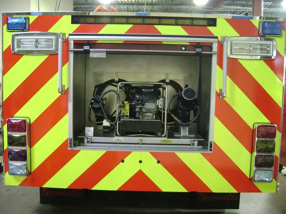 Exterior view of small fire truck showing cab, body compartments, and wheel/tire area.