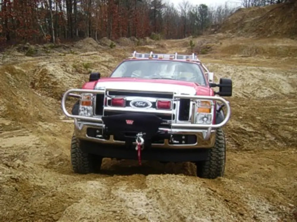 Exterior view of small fire truck showing cab, body compartments, and wheel/tire area.