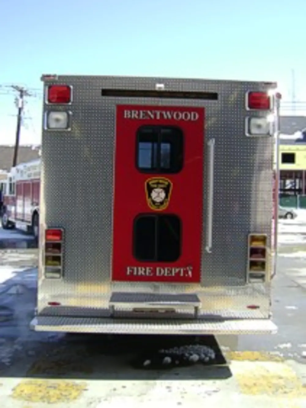 Front head-on view of rehab truck in front of garage doors.