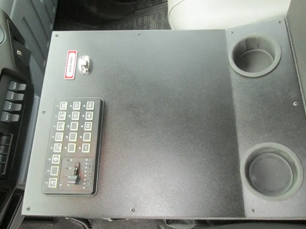 Exterior view of small fire truck showing cab, body compartments, and wheel/tire area.