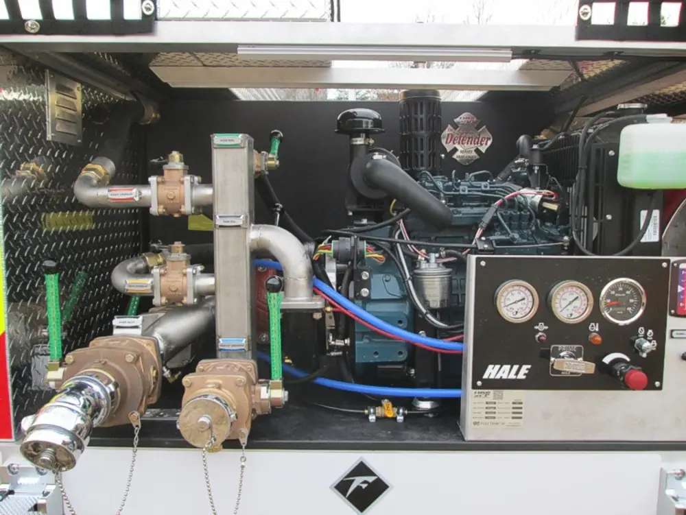 Exterior view of small fire truck showing cab, body compartments, and wheel/tire area.