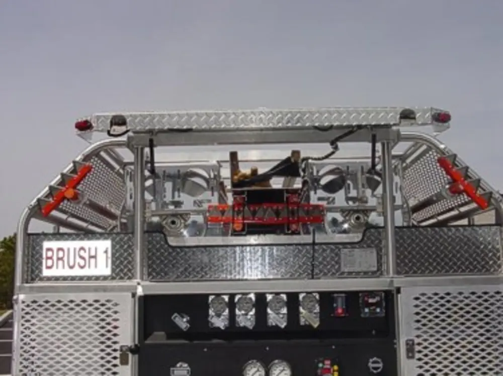 Exterior view of small fire truck showing cab, body compartments, and wheel/tire area.