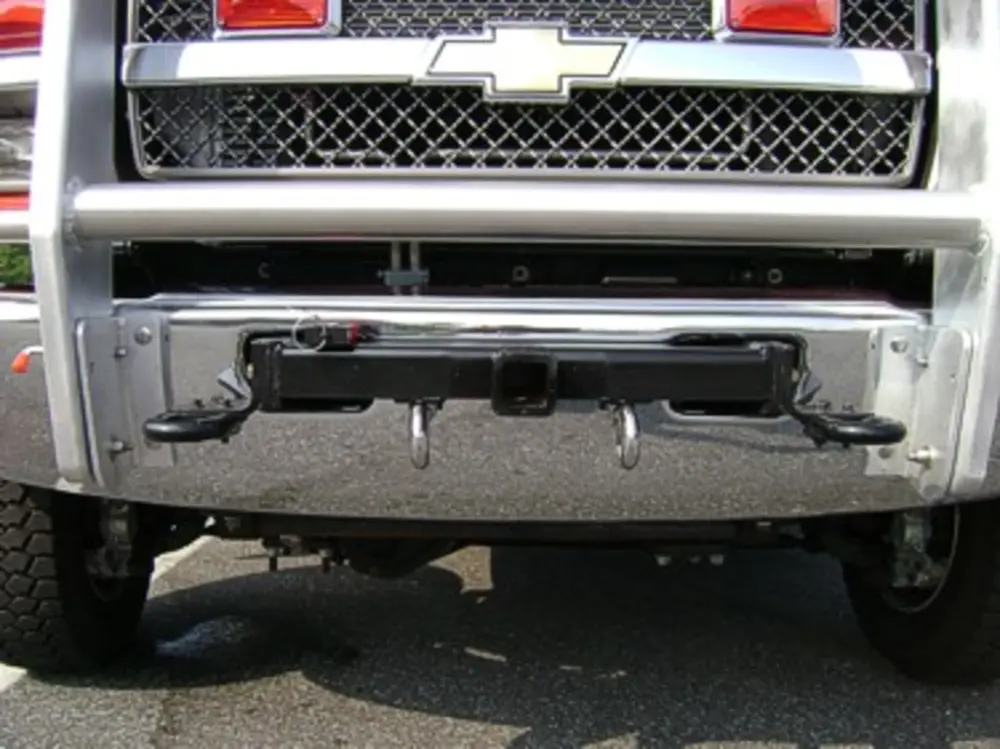 Exterior view of small fire truck showing cab, body compartments, and wheel/tire area.