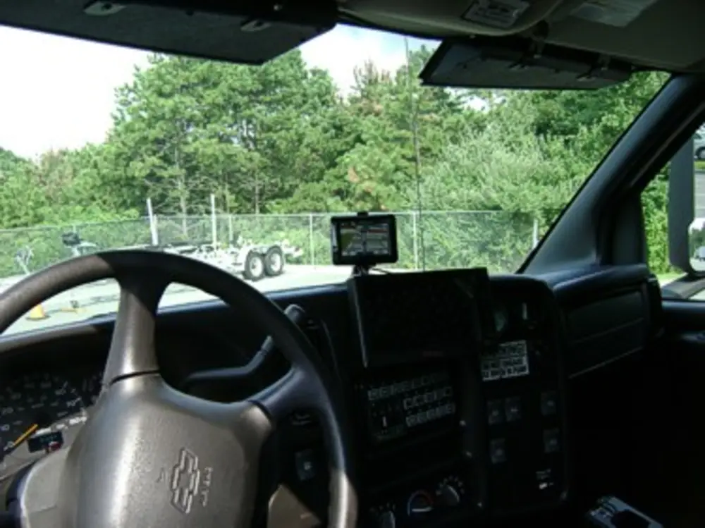 Exterior view of small fire truck showing cab, body compartments, and wheel/tire area.