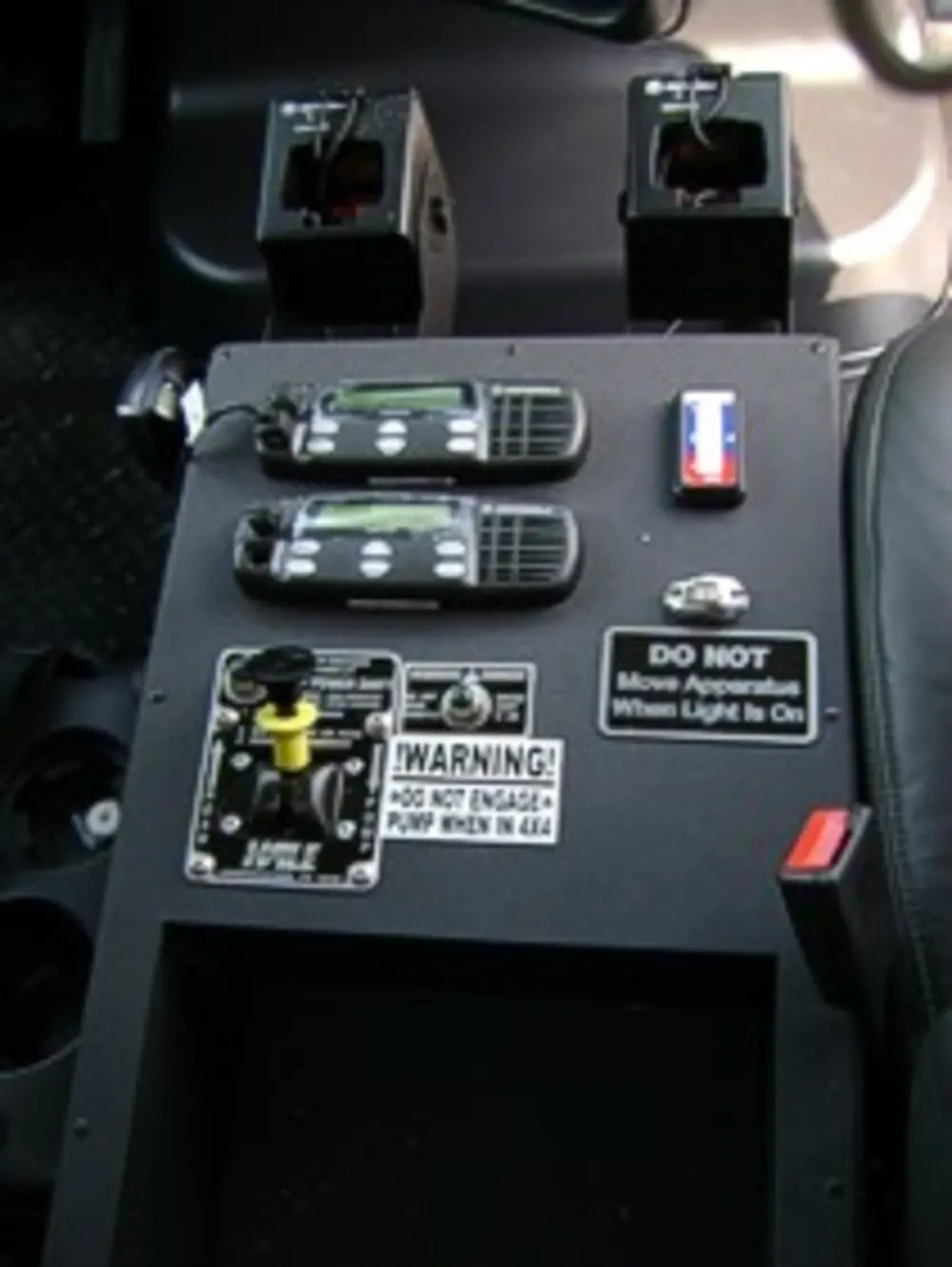 Exterior view of small fire truck showing cab, body compartments, and wheel/tire area.