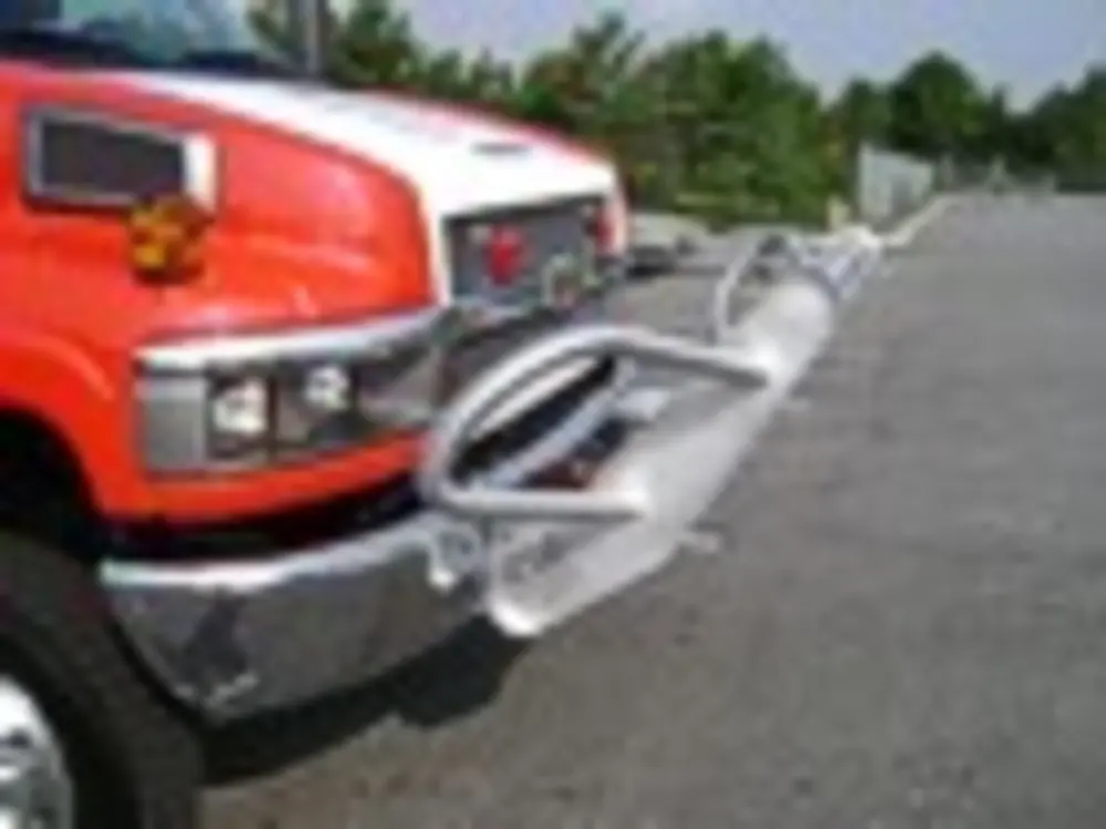 Exterior view of small fire truck showing cab, body compartments, and wheel/tire area.