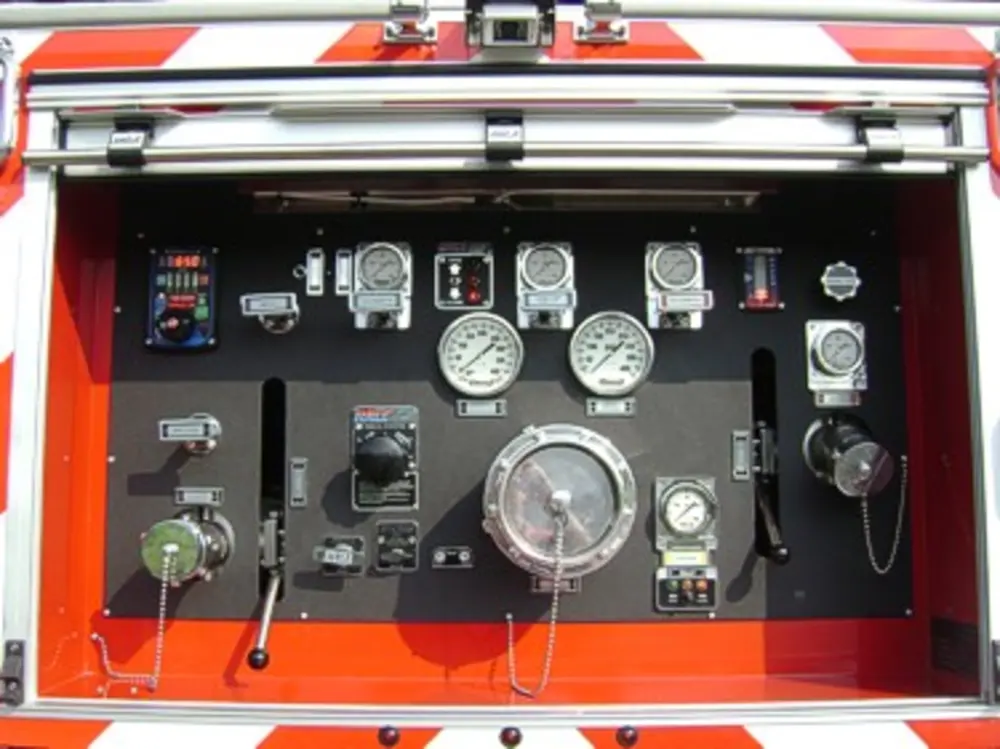 Exterior view of small fire truck showing cab, body compartments, and wheel/tire area.