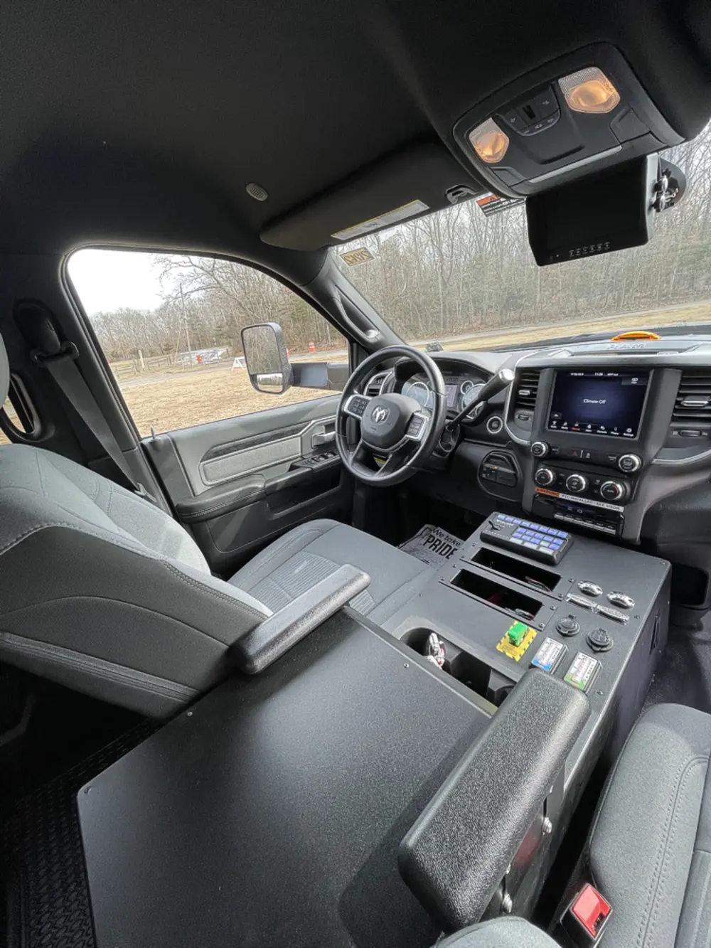 Exterior view of small fire truck showing cab, body compartments, and wheel/tire area.