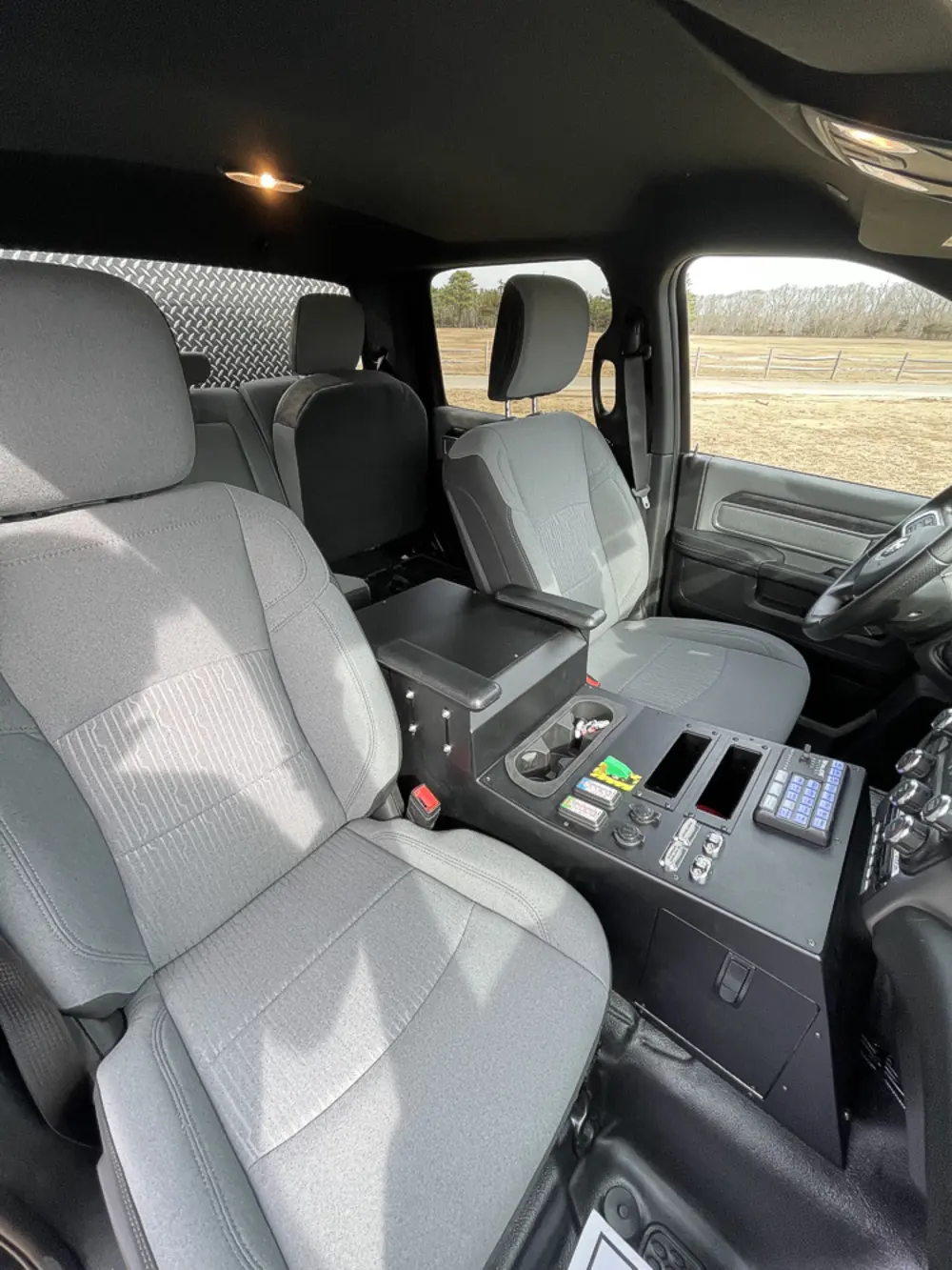 Exterior view of small fire truck showing cab, body compartments, and wheel/tire area.