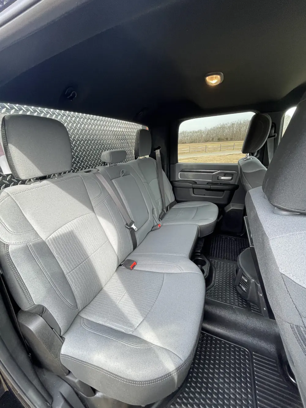 Exterior view of small fire truck showing cab, body compartments, and wheel/tire area.