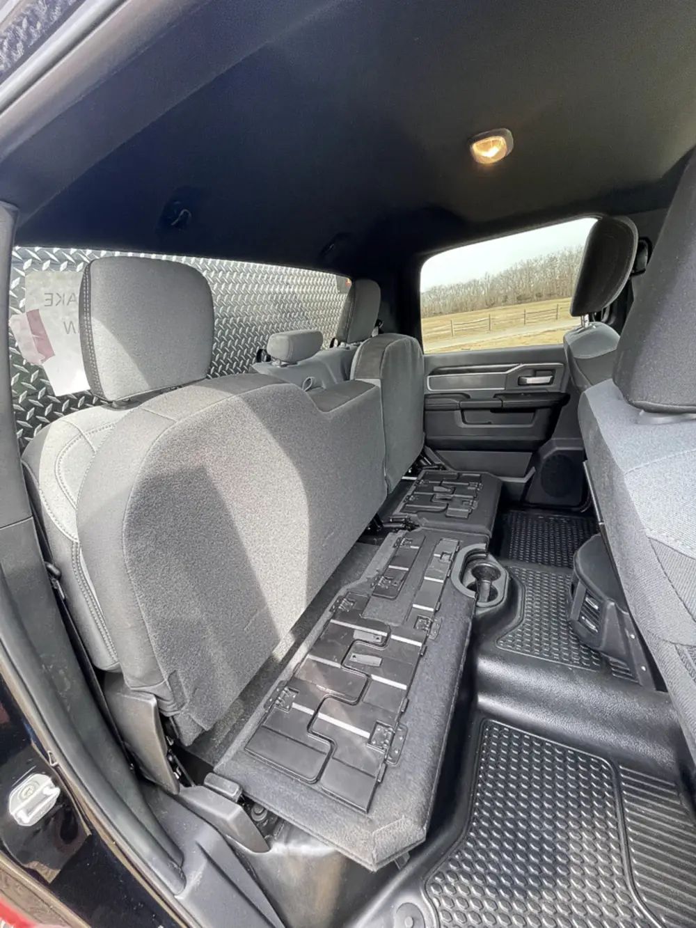 Exterior view of small fire truck showing cab, body compartments, and wheel/tire area.