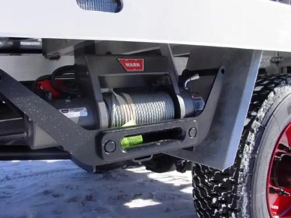 Exterior view of small fire truck showing cab, body compartments, and wheel/tire area.