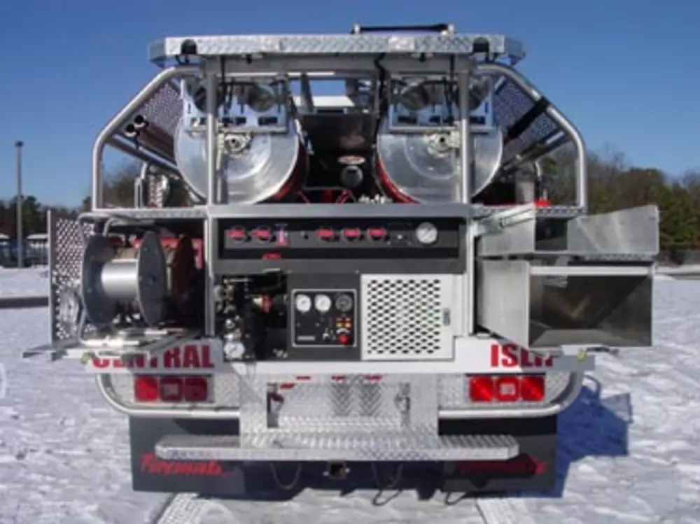 Exterior view of small fire truck showing cab, body compartments, and wheel/tire area.