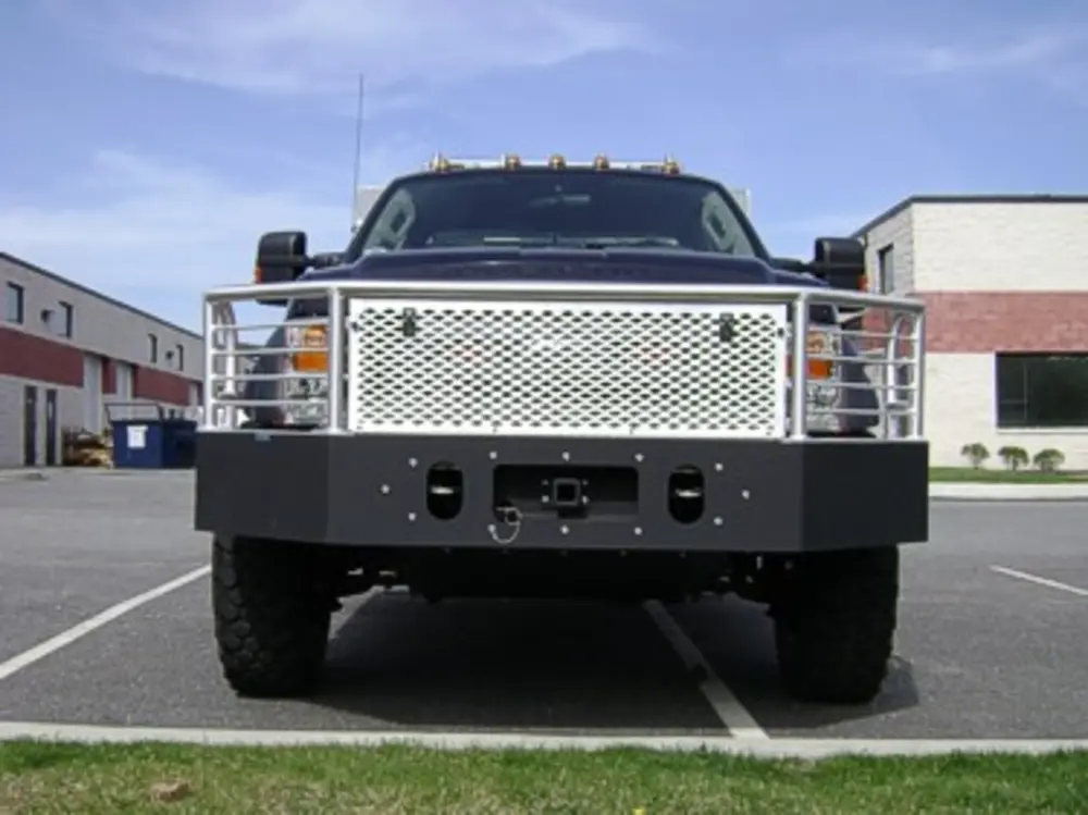 Exterior view of small fire truck showing cab, body compartments, and wheel/tire area.