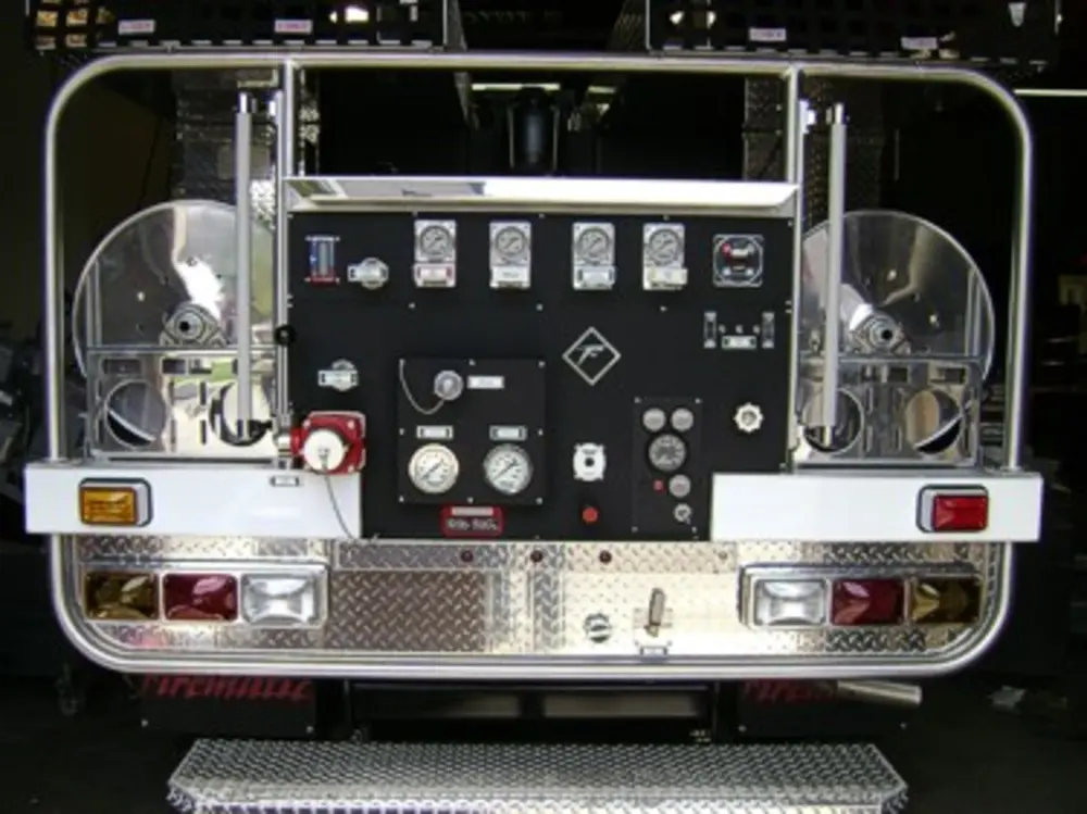 Exterior view of small fire truck showing cab, body compartments, and wheel/tire area.