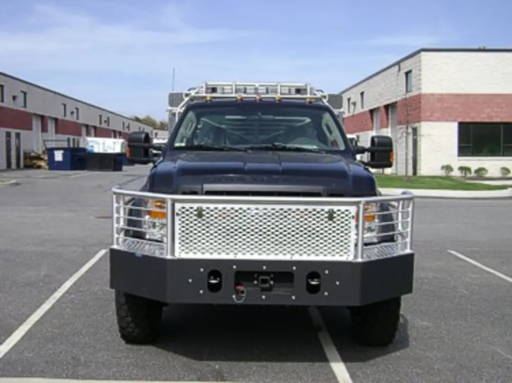 Exterior view of small fire truck showing cab, body compartments, and wheel/tire area.