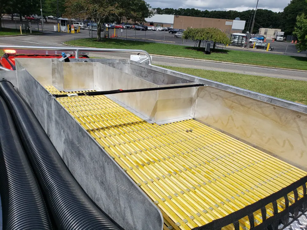 Exterior view of small fire truck showing cab, body compartments, and wheel/tire area.