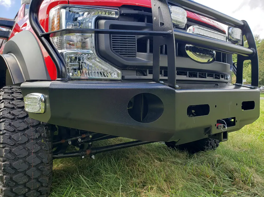 Exterior view of small fire truck showing cab, body compartments, and wheel/tire area.